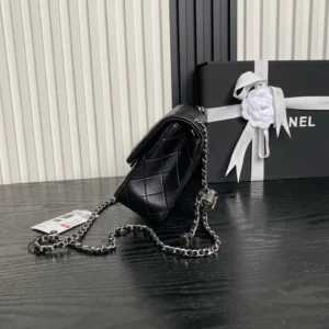 Black Chanel 25B Exquisite Double C-Button CF Series AS5 bag with silver chain, displayed beside a gift box, showcasing luxury design and craftsmanship.