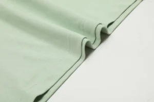 Repsgoat T-shirt pastel green cotton fabric close-up showing stitching and texture detail