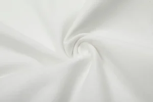 White fabric texture showcasing high-quality material for Vivienne Westwood's limited edition printed short sleeve top.