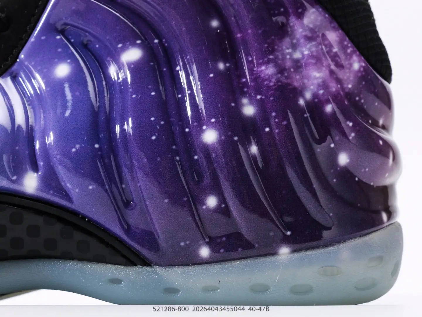 Nike Air Foamposite One NRG sneaker detail showcasing vibrant purple galaxy design with shimmering stars and smooth contours.