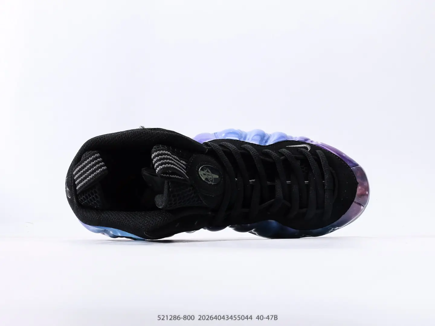 Nike Air Foamposite One NRG sneaker, top view showcasing black upper, unique iridescent sole, and lacing details, emphasizing style and quality for sneaker enthusiasts.