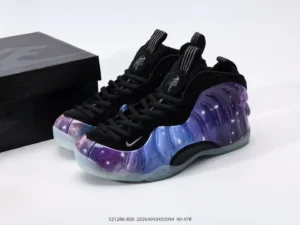 Nike Air Foamposite One NRG sneakers with a galaxy-inspired design and black accents, displayed alongside their box.