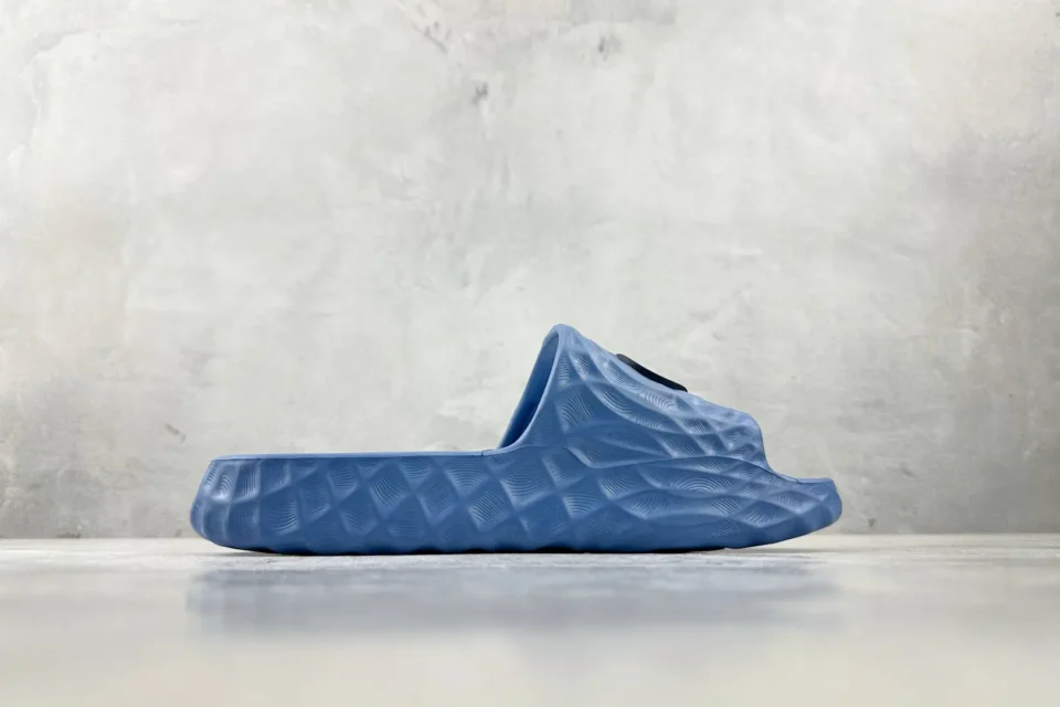 Yeezy Slide Slate blue EVA foam slip-on sandal with textured pattern and black logo tab