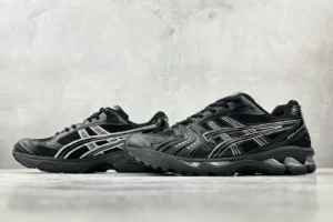 Asics Gel-Coffee 14 sneakers in black with silver detailing, displayed on a neutral background, highlighting their sporty design and contemporary style.