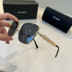 Dolce & Gabbana sunglasses black lenses gold metal frame logo embellished temples accessory