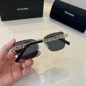 Dolce & Gabbana sunglasses black lenses gold metal frame logo chain temples accessory