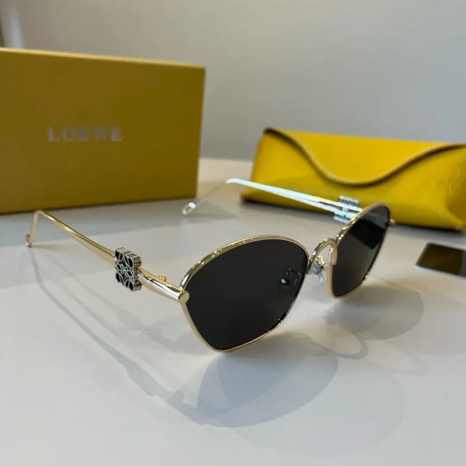 Loewe sunglasses gold metal frame black lenses luxury design with yellow textured leather case and yellow box background
