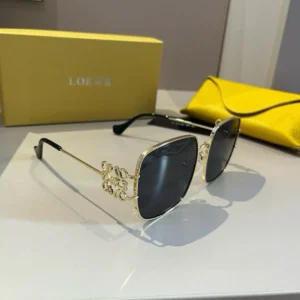Loewe sunglasses gold metal frame black lenses luxury design with ornamental temple details and yellow case