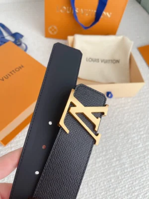 Louis Vuitton men's belt featuring a gold letter buckle, displayed with an orange branded box and beige dust bag, showcasing luxury replica accessory design.
