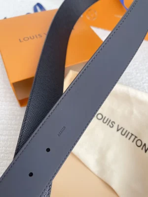 Louis Vuitton men's replica belt showcasing dual-sided calf leather design, with visible logo and packaging elements in the background, emphasizing luxury accessory quality.