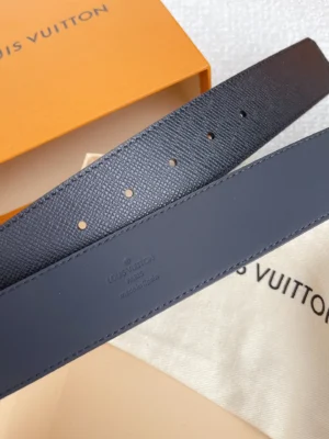 Louis Vuitton men's palm print belt replica in black, featuring a textured surface, adjustable holes, and branding details, displayed with an orange box and fabric pouch.