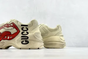 Gucci Rhyton Lip Print beige leather sneakers with bold red lip graphic and black logo lettering