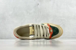 Gucci Screener Distressed Leather sneaker featuring a cream and green design, showcasing the iconic logo and lacing detail, set against a minimalist background.