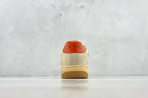 Gucci Screener Distressed Leather sneaker rear view showcasing orange heel and textured sole on a neutral background.