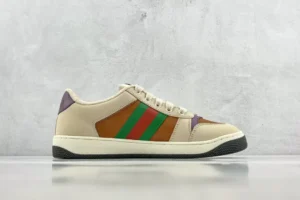 Gucci Screener distressed leather sneakers featuring a beige and brown color scheme with green and red stripes, set against a minimalist gray background.