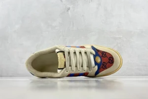 Gucci Screener Distressed Leather sneaker featuring a unique design with a beige upper, blue and red accents, and the iconic Gucci logo pattern.