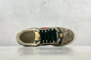 Gucci Screener Distressed Leather sneaker featuring a patterned upper, black laces, and signature Gucci colors, displayed from a top-down view.