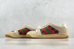 Gucci Screener distressed leather sneakers featuring signature green and red stripes and logo design, showcased on a minimalist background.