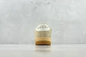 Gucci Screener distressed leather sneaker with logo at heel, showcasing minimalist design and gum sole.