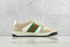 Gucci Screener Distressed Leather sneakers featuring beige and white colorway with green and red stripes, displayed on a neutral background.