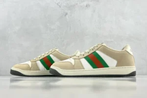 Gucci Screener Distressed Leather sneakers featuring beige upper, white accents, and green-red-green stripes, displayed on a neutral background.