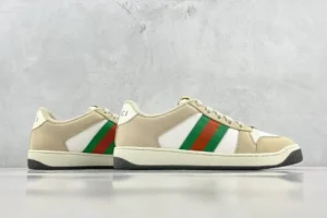 Gucci Screener Distressed Leather sneakers featuring beige upper with green and red stripes, displayed against a neutral background.