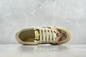 Gucci Screener Distressed Leather sneaker in beige with pink accents, featuring signature logo pattern and lace-up design, displayed from above on a neutral background.