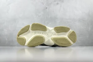 Balenciaga Triple S sneaker sole with prominent logo, showcasing design details on a textured surface.