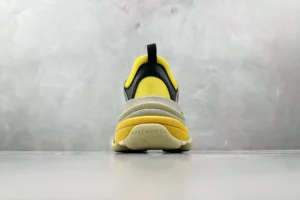 Gucci x Balenciaga Triple S Card sneaker featuring a yellow and gray design, viewed from the rear against a neutral background.
