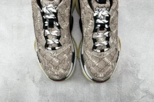 Gucci x Balenciaga Parisian Family Triple S Brown replica sneakers featuring a distinctive logo pattern, textured upper, and contrasting laces on a neutral background.