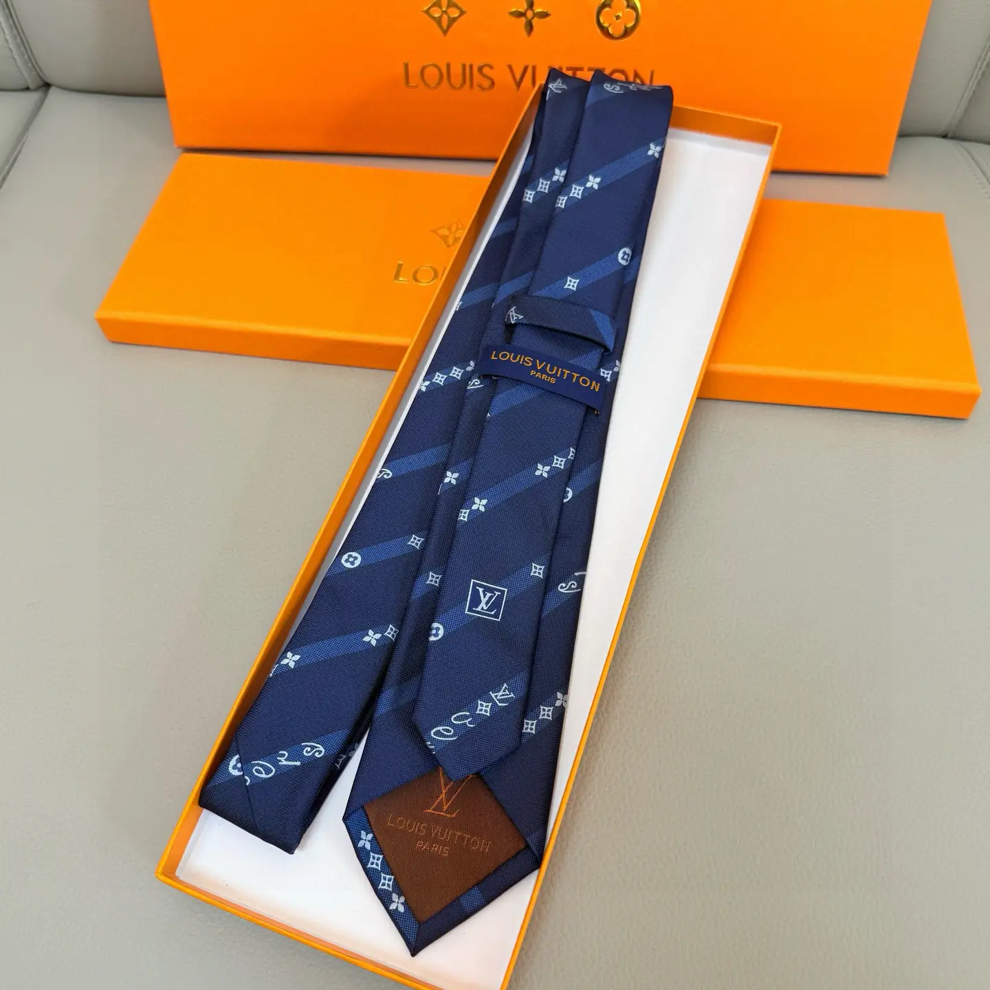 Louis Vuitton necktie blue silk with monogram pattern luxury accessory in orange box packaging