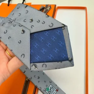 Hermès necktie gray silk with black horseshoe pattern and blue silk lining with H pattern