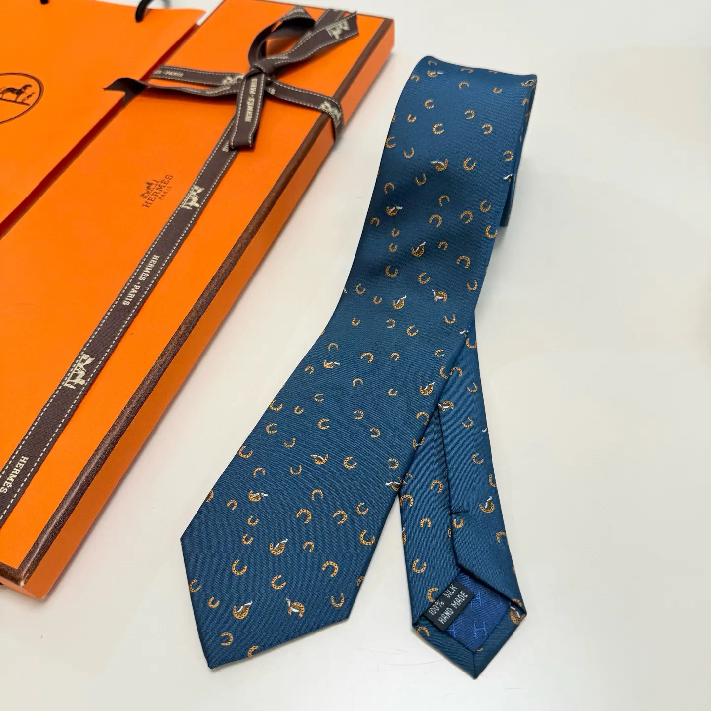 Hermes silk tie blue with horseshoe pattern and signature orange gift box packaging