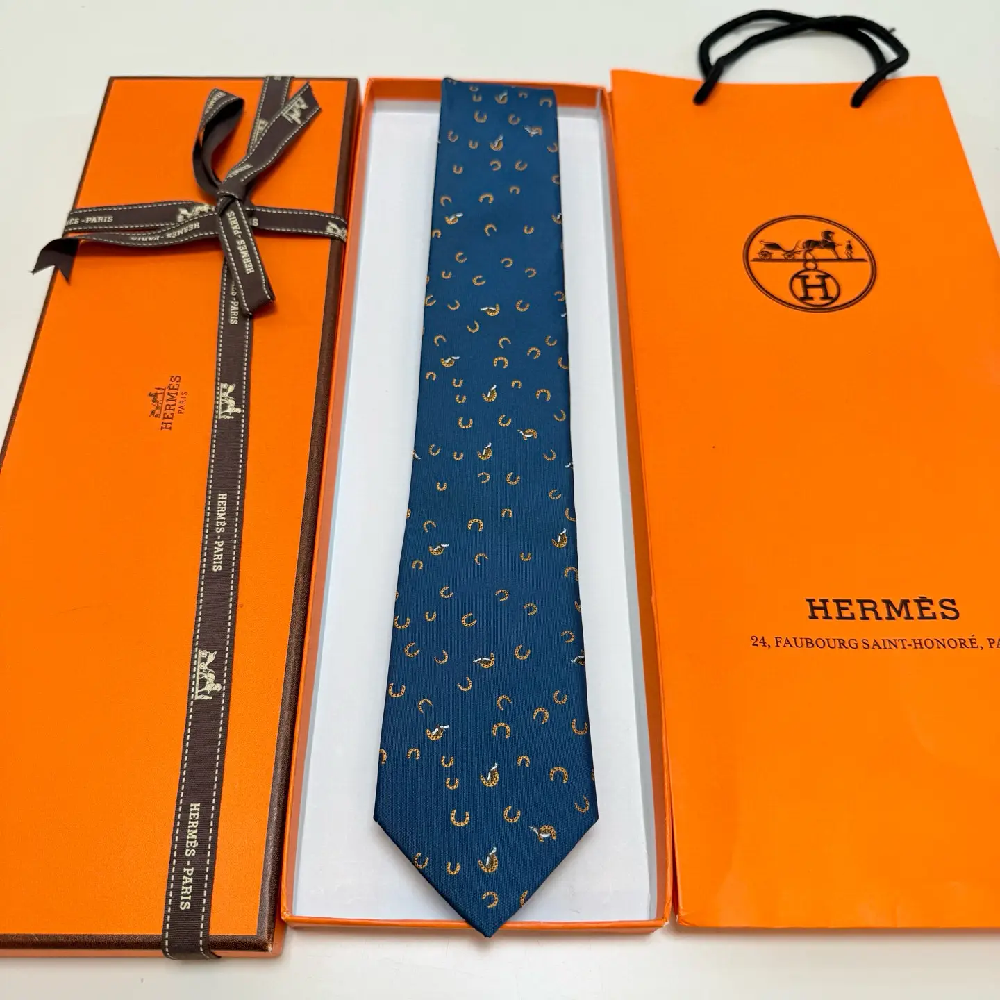 Hermès tie blue silk with brown horse shoe pattern luxury men's accessory in original orange box and bag