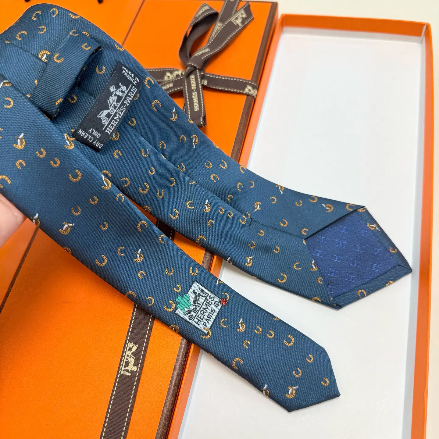 Hermes tie blue silk with orange horseshoe and horse motifs luxury men's accessory