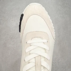Hermes Men’s Bouncing Sneaker in technical mesh, featuring a white upper with suede accents and a textured outsole, showcasing luxury footwear design.