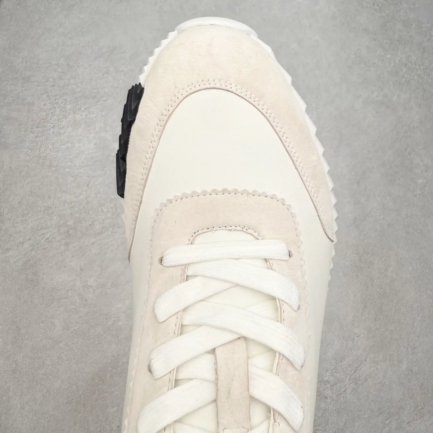 Hermes Men’s Bouncing Sneaker in technical mesh with white and beige colorway, featuring prominent laces and textured outsole, displayed on a neutral background.