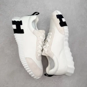 Hermes Men’s Bouncing Sneaker in white technical mesh with black detailing and textured outsole, showcasing luxury design and craftsmanship.
