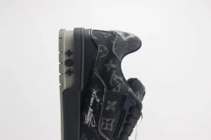 Louis Vuitton Trainer low-cut sneaker in black with signature monogram pattern and side logo detail, showcasing luxury footwear design.