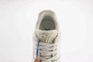 Top view of Tyler x Louis Vuitton Trainer sneaker, featuring white leather with gold logo and blue accent, showcasing luxury design details for replica footwear.