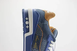 Tyler x Louis Vuitton Trainer sneakers featuring a blue and brown design, showcasing luxury craftsmanship and branding elements.