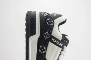 Louis Vuitton Trainer sneakers featuring a black and white design, showcasing the iconic LV logo, side profile view, luxury footwear for high-end fashion enthusiasts.