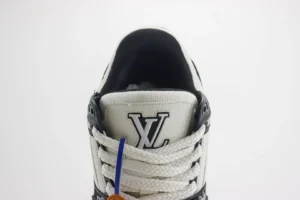 Louis Vuitton Trainer sneaker featuring the iconic LV logo, white and black color scheme, and detailed lacing design, emphasizing luxury footwear quality.