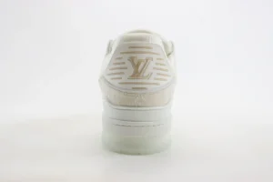 Louis Vuitton Trainer sneaker featuring a white and beige design with embossed logo, showcasing luxury craftsmanship and style.