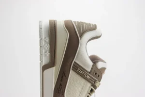 Tyler x Louis Vuitton Trainer sneaker in beige and brown, featuring signature Louis Vuitton branding and luxury design elements, showcased against a plain background.