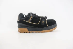 Louis Vuitton Trainer sneaker in black suede with gold accents and a gum sole, showcasing luxury craftsmanship and design.