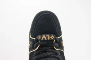 Louis Vuitton Trainer sneaker featuring a black upper with gold accents and logo detail, showcasing luxury craftsmanship and design.