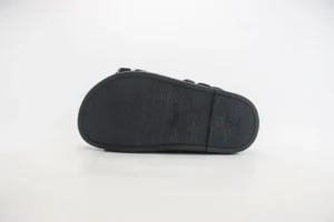 Louis Vuitton black sole slippers with textured rubber outsole and embossed LV logo detail