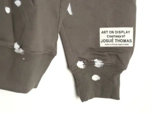 GALLERY DEPT GD Inkjet Hot Stamped Letter Hoodie featuring artistic distressing and tag reading "ART ON DISPLAY Courtesy of JOSUÉ THOMAS."