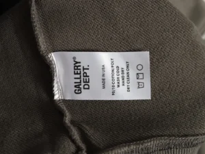 GALLERY DEPT. clothing label on a hoodie, detailing material composition and care instructions, highlighting the brand's focus on quality and craftsmanship.